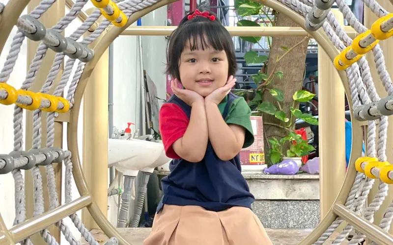 Bé cười tươi ở khu vận động ngoài trời